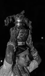 Portrait of woman dancing against black background