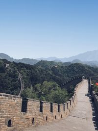 Great wall of china leading towards mountains against clear sky