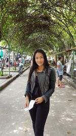 Portrait of beautiful woman standing on street in city