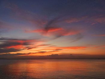 Scenic view of sea against dramatic sky during sunset