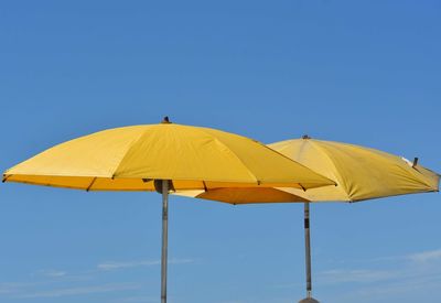 Low angle view of umbrella against blue sky