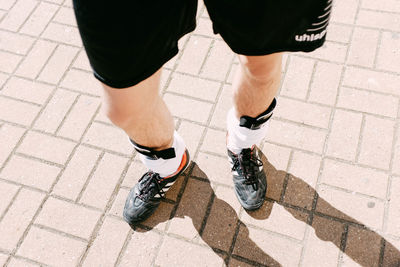Low section of man standing on tiled floor