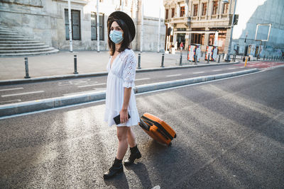 Woman with umbrella on street in city