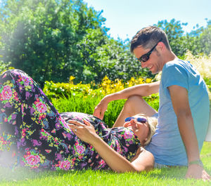 Man and woman relaxing on field at park