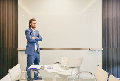 Businessman with arms crossed standing in conference room