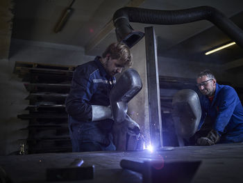 Worker welding in factory