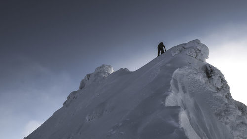 Low angle view of snowcapped mountain against sky