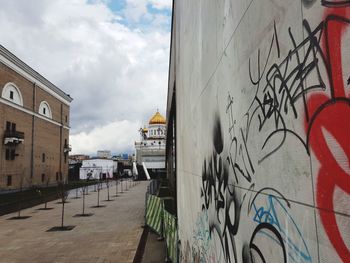 Graffiti on wall in city against sky