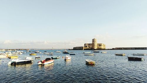 Boats in sea against buildings in city