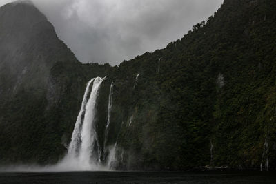 Scenic view of waterfall against sky