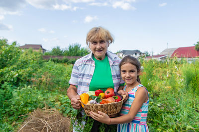 Portrait of smiling mother carrying daughter