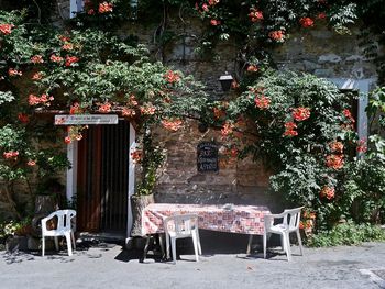 Empty chairs and tables against building