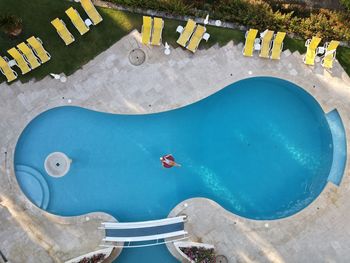 Aerial view of woman sitting on poo raft in swimming pool