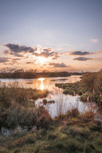 Scenic view of lake against sky during sunset