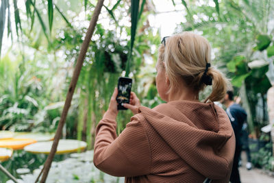 Side view of woman photographing through camera