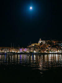 Illuminated buildings in water at night