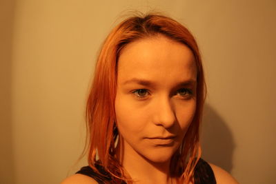 Close-up portrait of young woman against wall