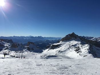 Scenic view of snowcapped mountains against clear blue sky