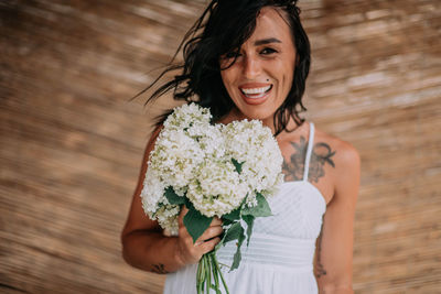 Portrait of a smiling young woman holding bouquet