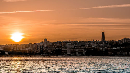 View of city at waterfront during sunset