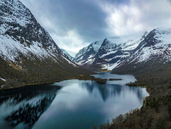 Scenic view of lake and snowcapped mountains against sky