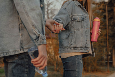 Hands of man and woman with bottles of water