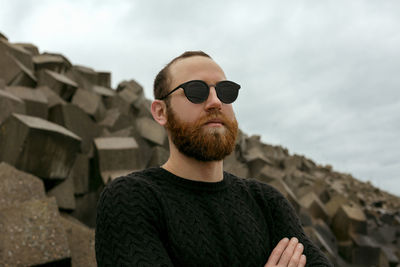 Young man wearing sunglasses against sky