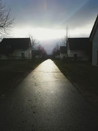 Empty road amidst buildings against sky