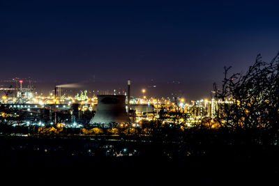 High angle view of illuminated factory against sky at night