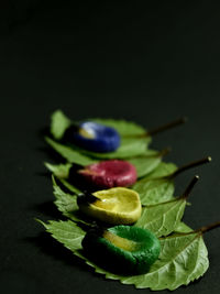 Close-up of green leaves on table against black background