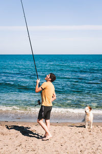 Full length of man standing on beach against sky