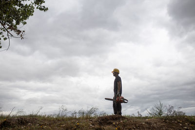 Low angle view of man standing on field against sky