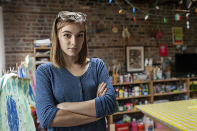Portrait of young woman standing against store