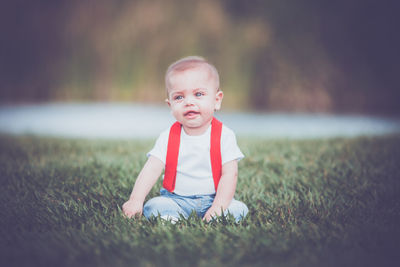 Portrait of cute girl sitting on field