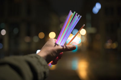 Close-up of hand holding multi colored lights