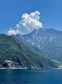 Scenic view of sea and mountains against sky