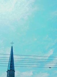 Low angle view of cables by church steeple against sky