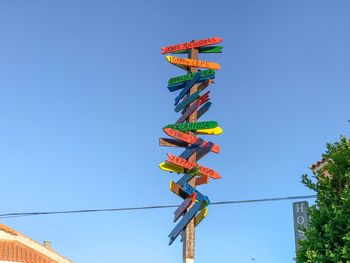 Low angle view of lanterns hanging against clear blue sky