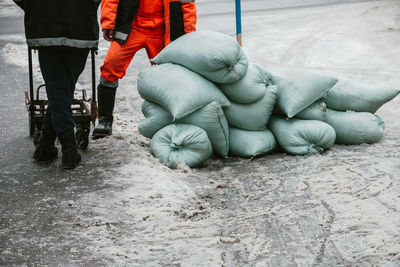 Low section of men with sacks standing on snow covered field