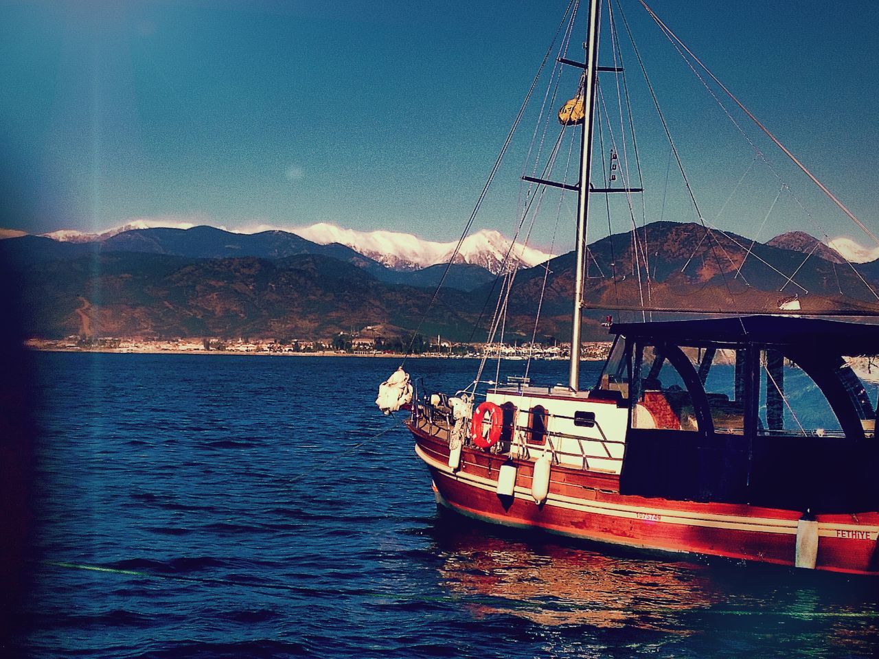 mountain, transportation, nautical vessel, water, mode of transport, mountain range, boat, waterfront, sky, nature, sea, scenics, beauty in nature, tranquil scene, tranquility, river, moored, lake, blue, mast