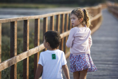 Young woman standing against railing