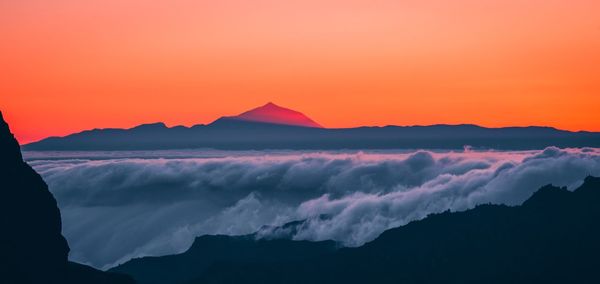 Scenic view of cloudscape and mountains during sunset