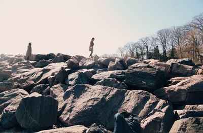 People standing on rocks against sky