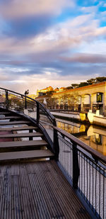 Bridge over river amidst buildings in city against sky