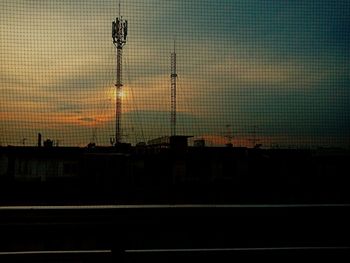 Silhouette of building against cloudy sky at dusk