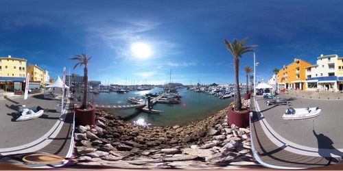 Boats moored at harbor against sky
