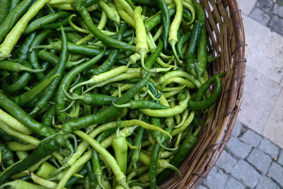 High angle view of green chili peppers in basket