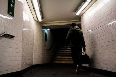 Rear view of man walking in subway