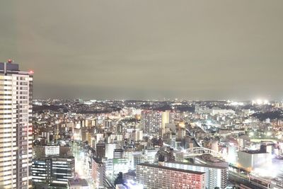 Illuminated cityscape against sky at night