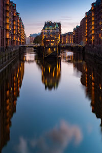 Reflection of buildings in river during sunset